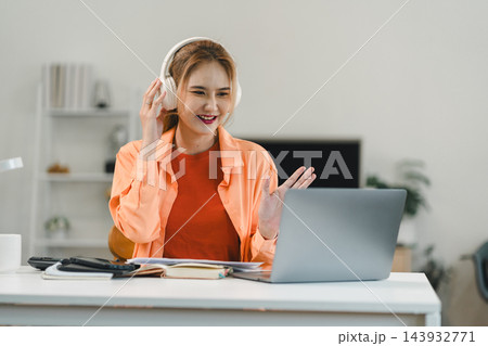 Remote communication of a professional woman wearing headphones at her desk 143932771