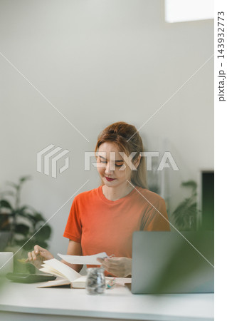 Financial planning of a young woman working from home Financial planning of a young woman working from home 143932773