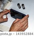 Nitra, Slovakia - August 4, 2026: Close View of Hands Using Smartphone Near Radio Tubes 143932884
