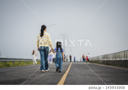 mother and preschool child girl holding hand and walking on a road on mountain in morning mother and preschool child girl holding hand and walking on a road on mountain in morning 143933008