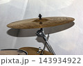 Bronze Drum Cymbal Mounted on Metal Stand in Indoor Setting 143934922