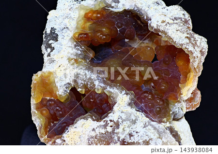 Striking close-up of a kidney-shaped chalcedony specimen with botryoidal formations on a dark backdrop. Prioksky or Golutvin quarry, Moscow region, Russia Striking close-up of a kidney-shaped chalcedony specimen with botryoidal formations on a dark backdrop. Prioksky or Golutvin quarry, Moscow region, Russia 143938084