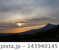 磐梯山の夕景。雲のカーテンに包まれる太陽と仕切られたオレンジ色と水色の空が印象的で綺麗だ。 143940145