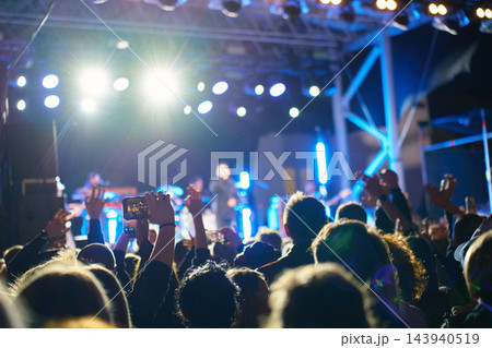 People standing in crowd at outdoor concert at night People standing in crowd at outdoor concert at night 143940519