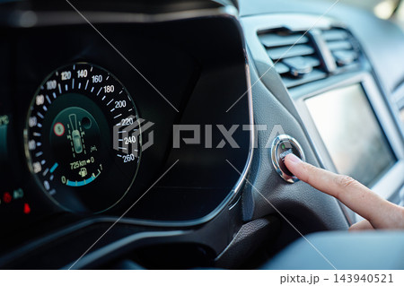 Close-up of finger pressing car engine start button 143940521