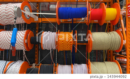 Assorted colorful ropes and cords wound on large reels displayed for sale at hardware store Assorted colorful ropes and cords wound on large reels displayed for sale at hardware store 143944092