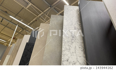 Large decorative wall panels with marble, stone and wood textures displayed vertically at home improvement store 143944162