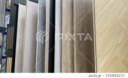 Wood effect flooring samples in different colors, shades and textures displayed in home improvement store 143944253