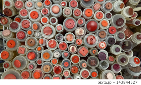 Assorted colorful sewing buttons in different shapes, sizes and textures displayed in craft store, close-up background Assorted colorful sewing buttons in different shapes, sizes and textures displayed in craft store, close-up background 143944327