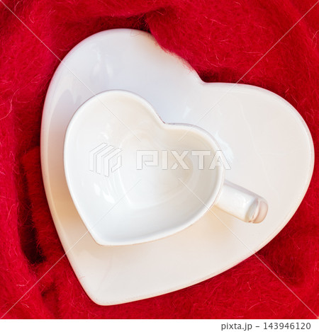 Empty heart shaped cup on red Empty heart shaped cup on red 143946120