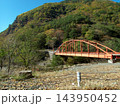 南アルプス林道の車窓から望む秋の山々と渓谷に架かる赤いアーチ橋 143950452