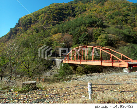 南アルプス林道の車窓から望む秋の山々と渓谷に架かる赤いアーチ橋 南アルプス林道の車窓から望む秋の山々と渓谷に架かる赤いアーチ橋 143950452