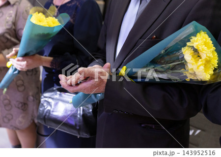 A crowd gathers with flowers in their hands to celebrate a local event in 143952516
