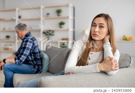 Mature couple sitting on couch after quarrel, feeling offended, not talking to each other, having relationship problems at home. Spouses after family conflict, breakup, relationship crisis concept Mature couple sitting on couch after quarrel, feeling offended, not talking to each other, having relationship problems at home. Spouses after family conflict, breakup, relationship crisis concept 143953800