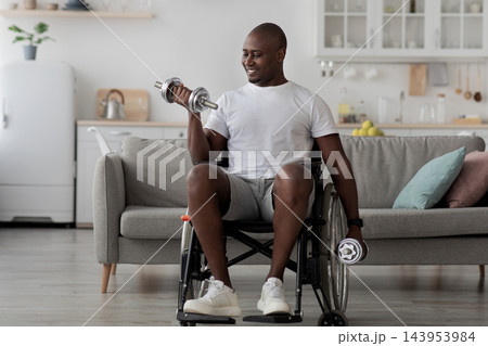 Keep fit alone, exercises for muscle, workout and recovery at home, covid-19 quarantine. Smiling adult african american man in wheelchair lift up dumbbell in living room interior, copy space Keep fit alone, exercises for muscle, workout and recovery at home, covid-19 quarantine. Smiling adult african american man in wheelchair lift up dumbbell in living room interior, copy space 143953984