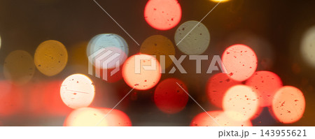 Abstract blurred lights create colorful bokeh circles in red, orange, white and blue against dark evening background. Soft glowing highlights suggest traffic, nightlife and urban motion at night Abstract blurred lights create colorful bokeh circles in red, orange, white and blue against dark evening background. Soft glowing highlights suggest traffic, nightlife and urban motion at night 143955621