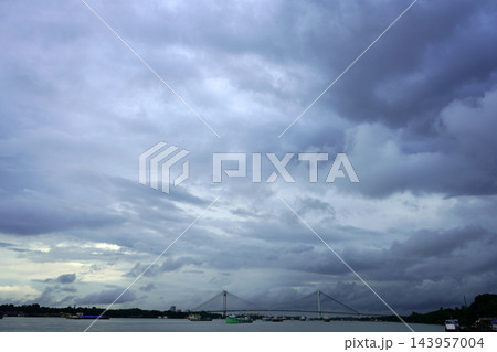 Dramatic dark monsoon clouds hovering over Vidyasagar Setu cable stayed bridge and Hooghly river in Kolkata Dramatic dark monsoon clouds hovering over Vidyasagar Setu cable stayed bridge and Hooghly river in Kolkata 143957004