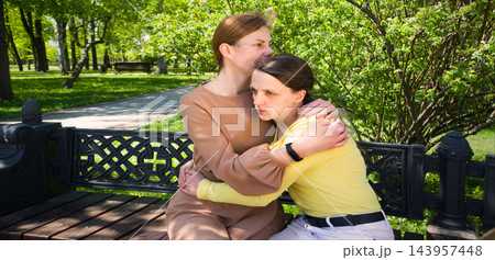 Two girls hug one another 143957448