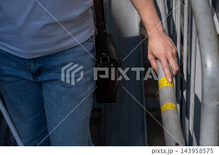 A blind woman reads the inscription on the railing of a staircase.  143958575