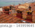 Old brick chimneys on terracotta roof 143959645