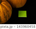 Pumpkins and a green note on a dark surface for Halloween decoration 143960458