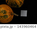 Pumpkins on a dark surface in celebration of Halloween and autumn harvest 143960464