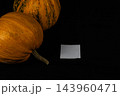 Pumpkins sit on a black surface for Halloween decoration in October 143960471
