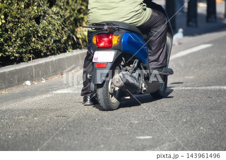片足をついて停止線に停車する原付バイク 片足をついて停止線に停車する原付バイク 143961496