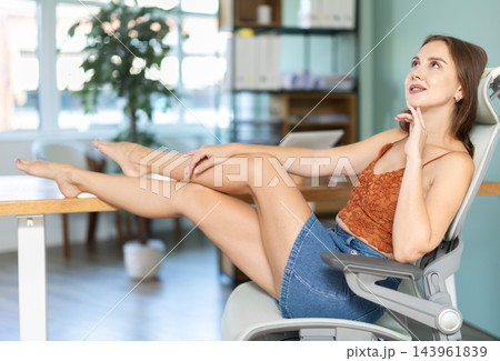 European woman in skirt posing in office arm chair European woman in skirt posing in office arm chair 143961839