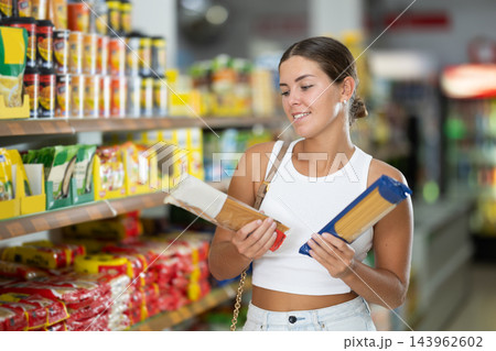 Girl buyer chooses between variation of noodles 143962602