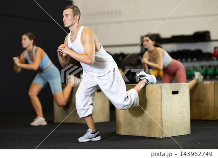 Young man training with crossfit box Young man training with crossfit box 143962749