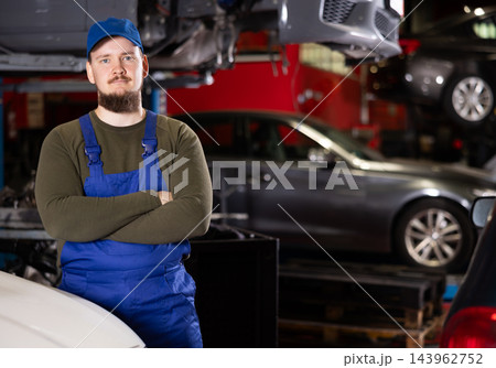 Young guy mechanic posing at car service station 143962752