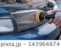 The process of polishing car headlights outdoors.  143964874