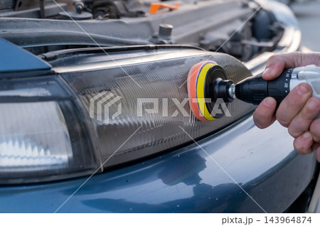 The process of polishing car headlights outdoors.  143964874