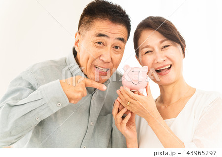 豚の貯金箱を持つ熟年夫婦 143965297