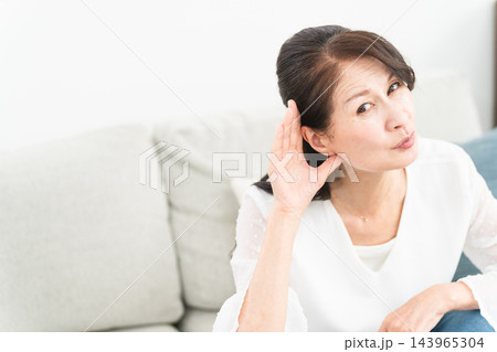 耳に手を当てて聞きかえす熟年女性 耳に手を当てて聞きかえす熟年女性 143965304