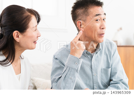 補聴器を付けた熟年男性と喜ぶ女性 補聴器を付けた熟年男性と喜ぶ女性 143965309