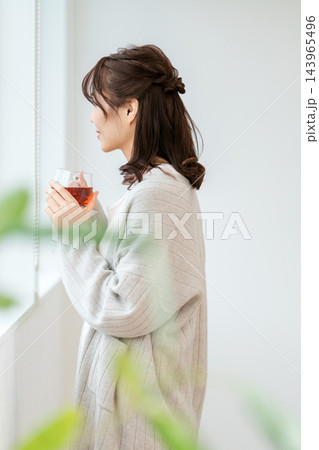 窓辺で紅茶を持つルームウェア姿の女性の横顔 143965496