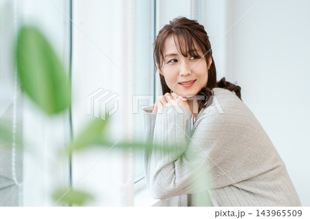 窓辺に寄りかかって微笑む女性 窓辺に寄りかかって微笑む女性 143965509
