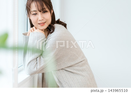 窓辺で頬杖をついて穏やかに過ごす女性 143965510