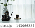 Coffee in a small cup and black pot and coffee beans jar on white table 143966225