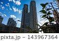 青空に映える東京都庁舎と新宿中央公園の木々・高層ビル群 143967364