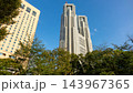 青空に映える東京都庁舎と新宿中央公園の木々・高層ビル群 143967365