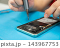 A technician is repairing a smartphone. 143967753