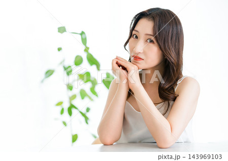 両手を顔のそばに添える女性の美容ポートレート 143969103
