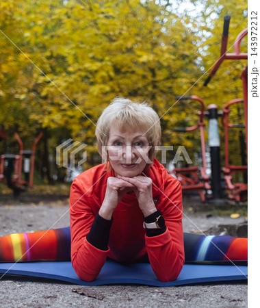 Mature woman practicing yoga and stretching outdoors in an autumn park. Active senior enjoying healthy aging, fitness, and vitality through outdoor workout and mindfulness. Mature woman practicing yoga and stretching outdoors in an autumn park. Active senior enjoying healthy aging, fitness, and vitality through outdoor workout and mindfulness. 143972212