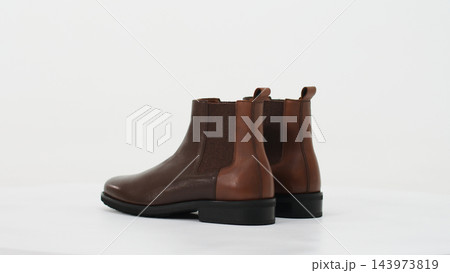 Pair of brown leather Chelsea boots for men with elastic side panels and pull tabs, elegant classic footwear Pair of brown leather Chelsea boots for men with elastic side panels and pull tabs, elegant classic footwear 143973819