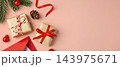 Christmas background with gift box, red envelope, and pine branches on a pink background, copy space 143975671