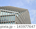 Modern building facade with concrete grid structure, large windows and glass balcony 143977647