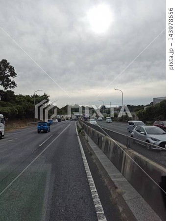曇り空の下を車が行き交う日本の幹線道路風景 143978656